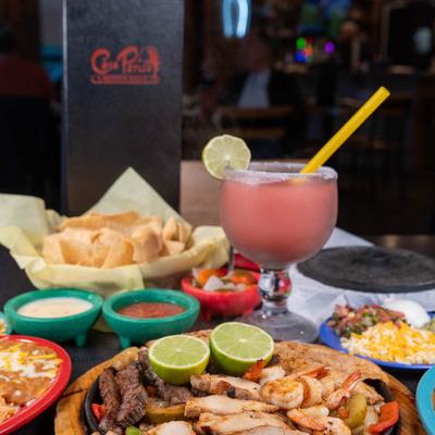 Assorted food dishes with a pink margarita drink on the table.