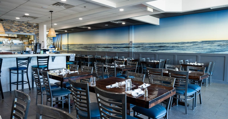 Interior, dining area, wooden top tables with chairs, ready for guests, tile flooring
