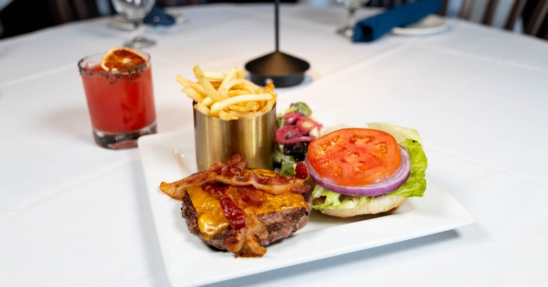 Bacon Cheese Burger served with fries, alongside a cocktail