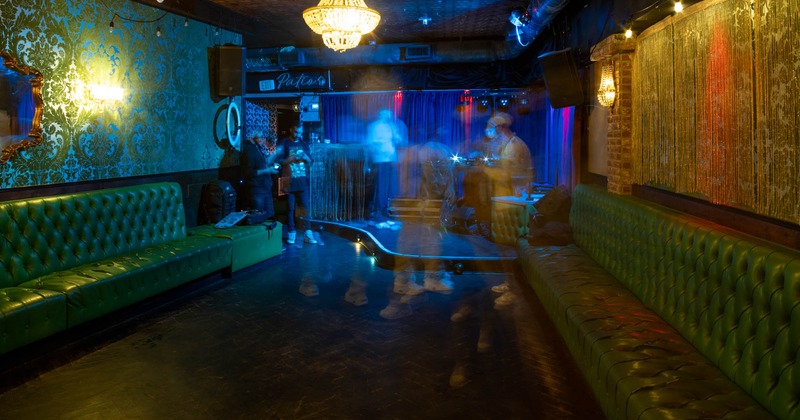 Interior, low seating banquette benches, stage, vintage wallpaper on the walls