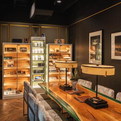 A cozy cigar lounge featuring a wooden table surrounded by elegant chairs