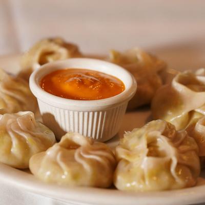 Chicken Momo served with a dipping sauce.
