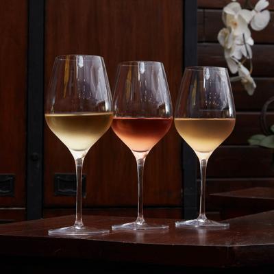 Three glasses of wine on a bar counter with white orchid.