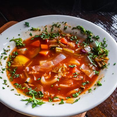 A bowl of Minestrone soup garnished with parsley.
