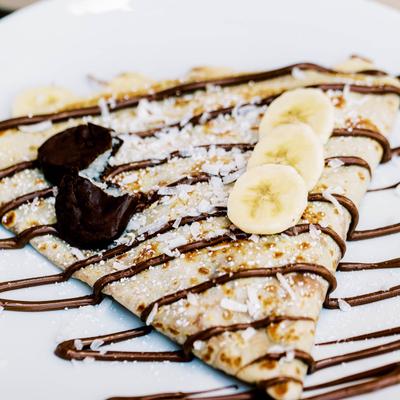 Banana and chocolate crepe topped with coconut flakes.