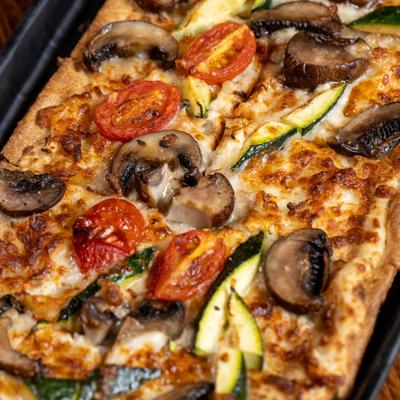 Flatbread topped with fire-roasted vegetables, cremini mushrooms, mozzarella, and garlic cream.