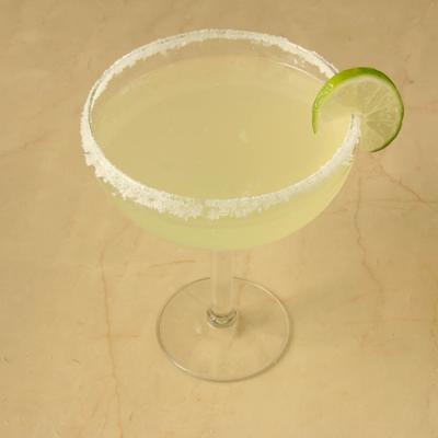 Margarita rimmed with salt and garnished with lime wheel.