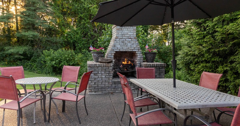 Exterior, tables and chairs near fireplace