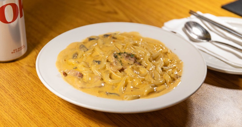 Cream Udon with chopped onions, white mushrooms, and bacon