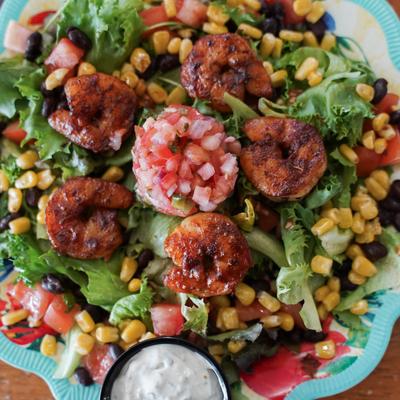 Blackened shrimp salad with grilled corn, black beans, salsa, and lettuce.