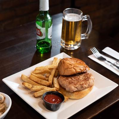 Hamburger, served with fries and ketchup, a glass of beer.