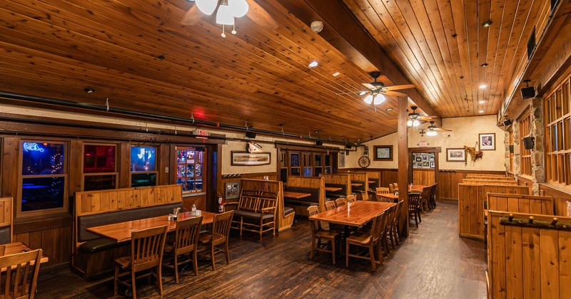 Restaurant interior with wooden decor, tables, chairs, and booth seating