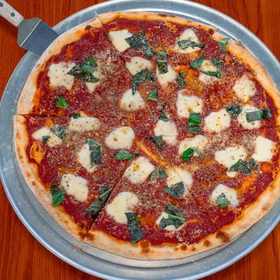 Margherita pizza topped with fresh basil.