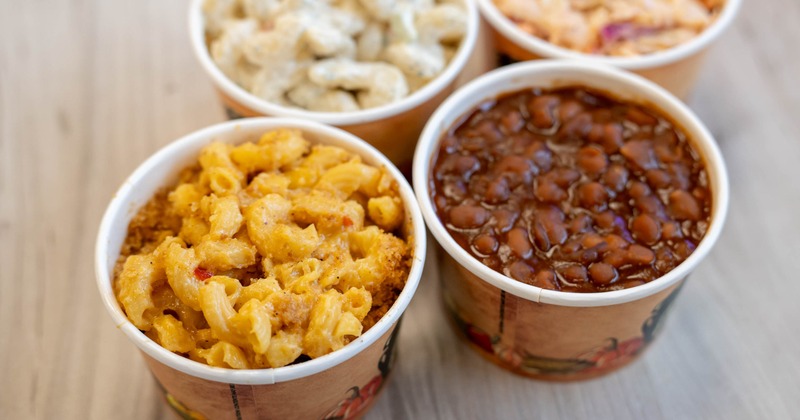 A selection of barbecue side dishes served in takeaway containers