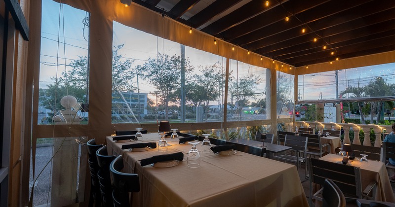 Cozy enclosed patio with dining tables set and ready for guests