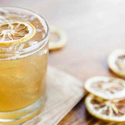Craft cocktail on the rocks with a dehydrated lemon wheel.