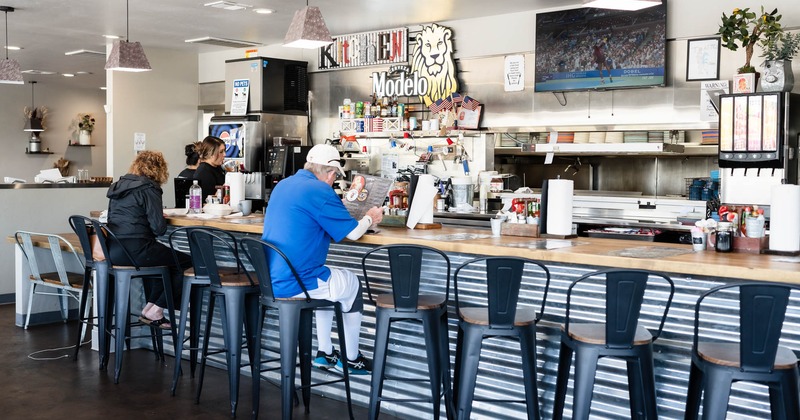 Interior, bar area, bar and bar stools, guests sitting at the bar