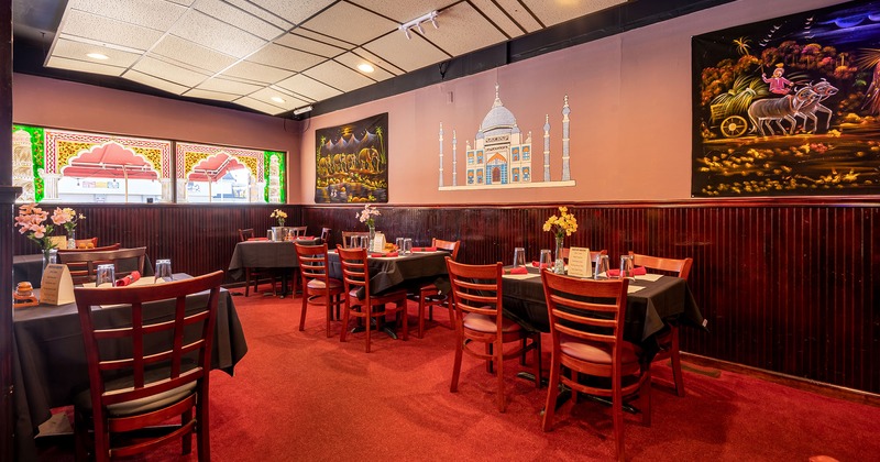 Set dining area ready for guests, Taj Mahal mural and paintings depicting traditional life