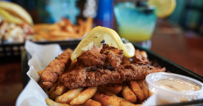 Fried salmon strips with fries and dipping sauce