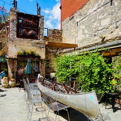 Outdoor patio featuring a unique repurposed canoe fire pit and a line of chairs.