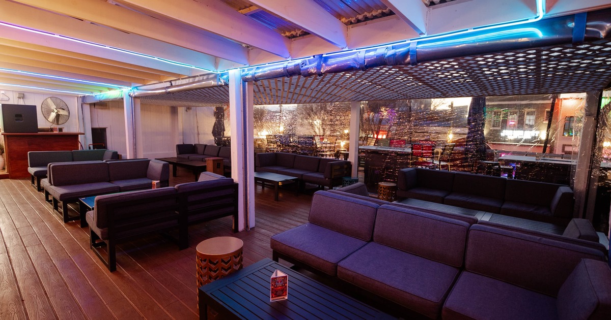 Interior, seating and lounge area, modular gray sofas wit low tables, wooden decking