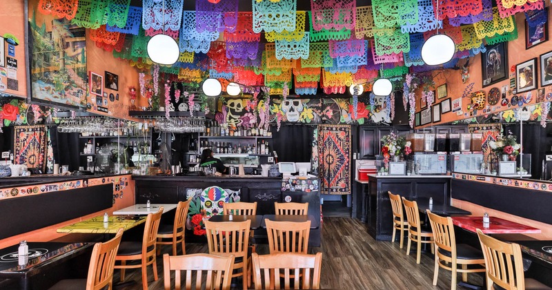 Colorful interior, seating area, wooden tables and chairs, bar, various Mexican motif decoration