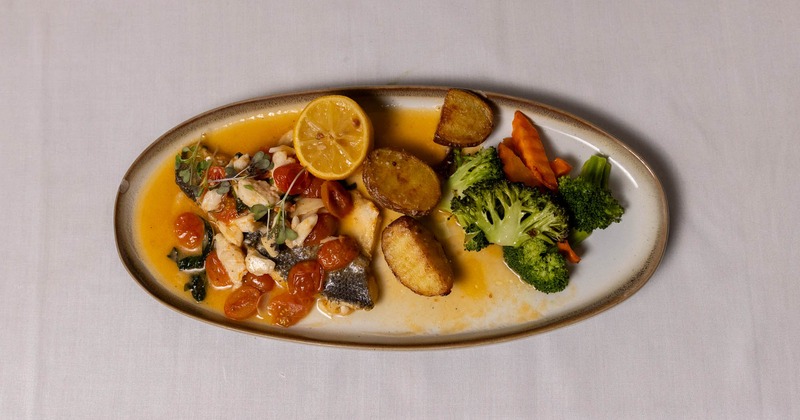 Branzino with crab meat, potatoes, broccoli, and cherry tomatoes