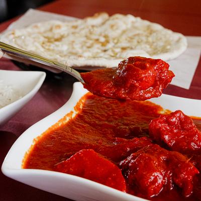 Meat pieces with spices and an onion and tomato gravy, served with rice and naan.