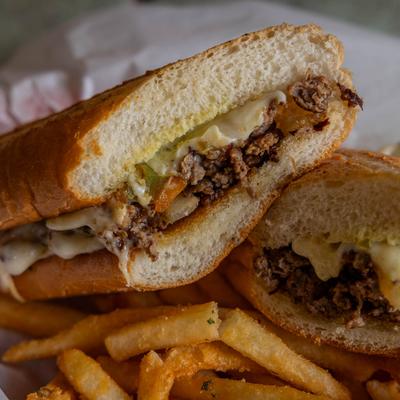 Philly Cheesesteak sandwich served with fries.