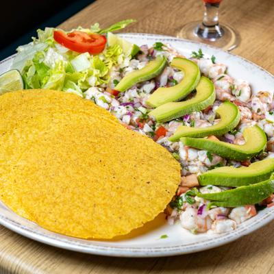 Shrimp ceviche topped with avocado slices and served with crispy tostadas.