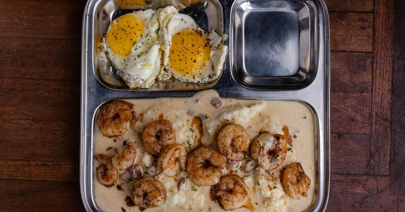 Shrimp and grits served with two sunny-side-up eggs
