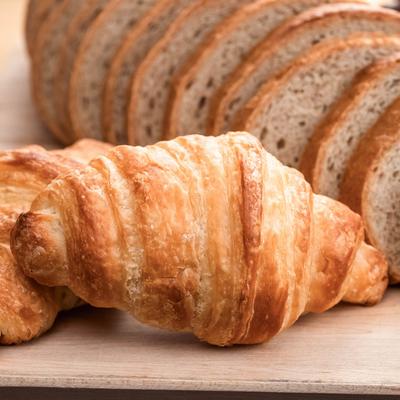 Close up of two croissants and bread slices.