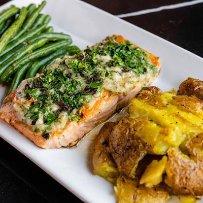 Herb salmon with two side items.