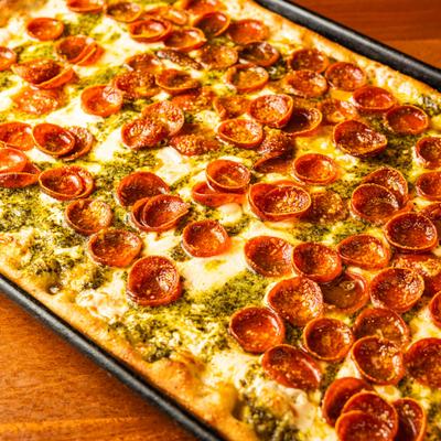 Pepperoni and pesto pizza.