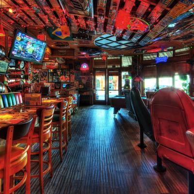 Colorful bar with vintage decor, neon signs, and eclectic seating