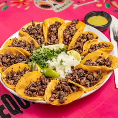 Portion of taqitos with sour cream and cilantro in the midle of the plate.