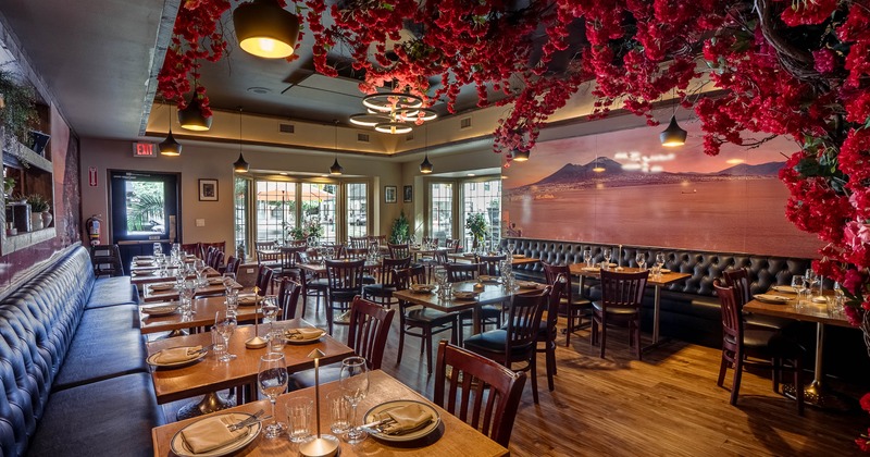 Elegant restaurant dining room with floral ceiling decor and scenic wall mural