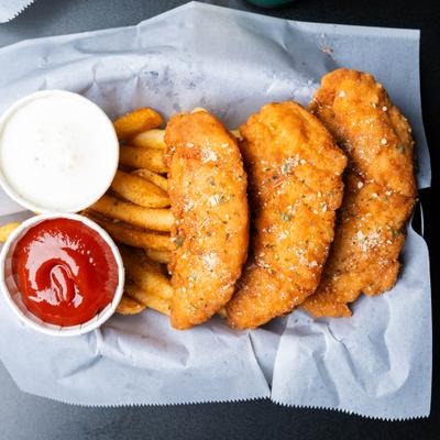 Crispy breaded chicken tenders served with fries and ketchup.