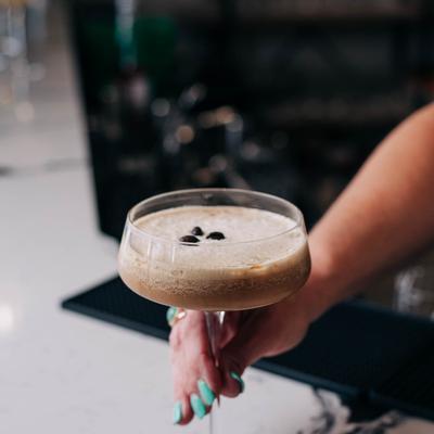 A glass of Espresso Martini in hand.