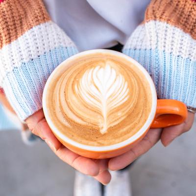 Hands holding a latte.