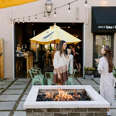 Exterior patio, two guests enjoying their cocktails by the fire pit