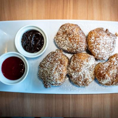 Beignets dusted with powdered sugar served with chocolate and berry dipping sauces.
