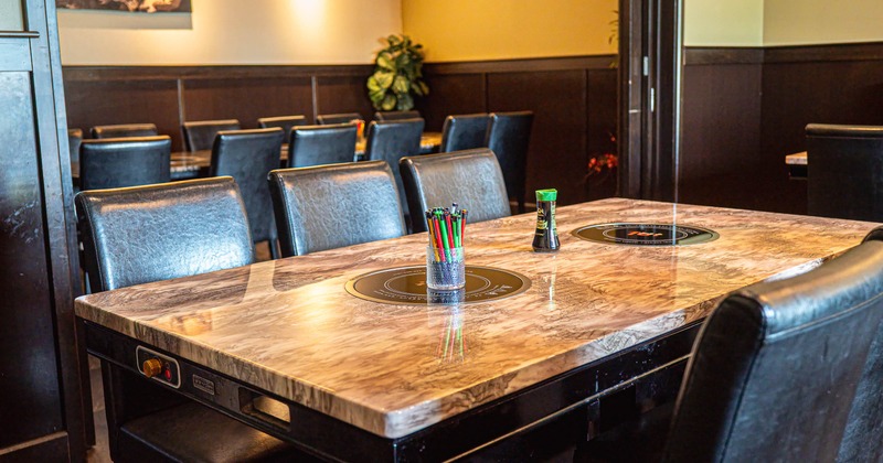 Cozy restaurant interior with marble dining table and black leather chairs