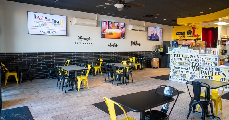 Interior, seating area with tables and chairs, TVs on the wall