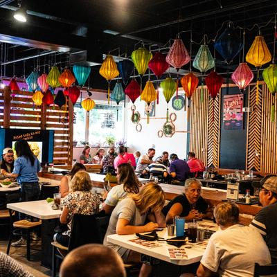 Dining area featuring colorful hanging lanterns and busy diners.