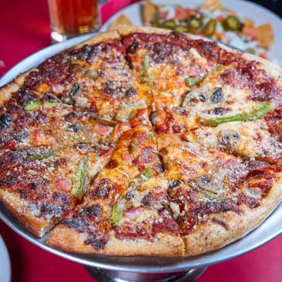 Thin-crust pizza with various toppings.