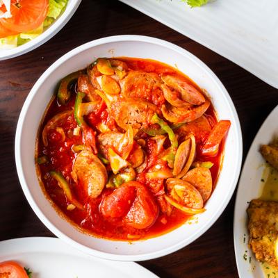 Sausage and peppers in tomato sauce, servced in a bowl.