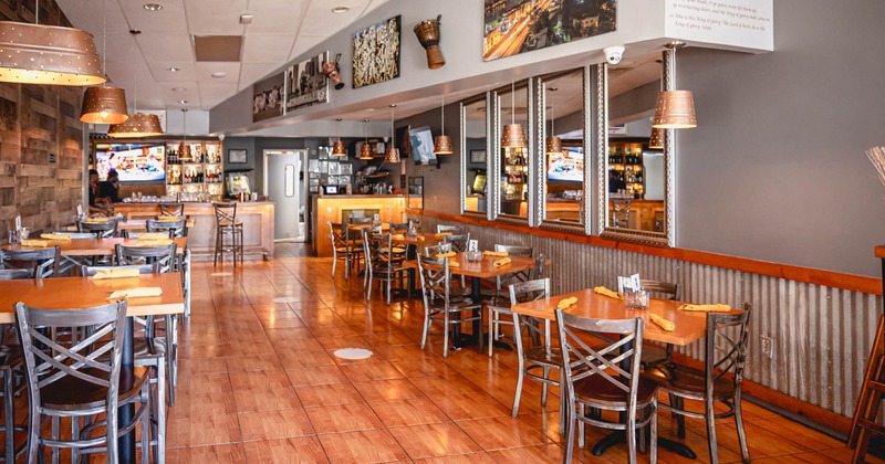 Interior, dining area, tile flooring, bar in the back, large mirrors on the right wall