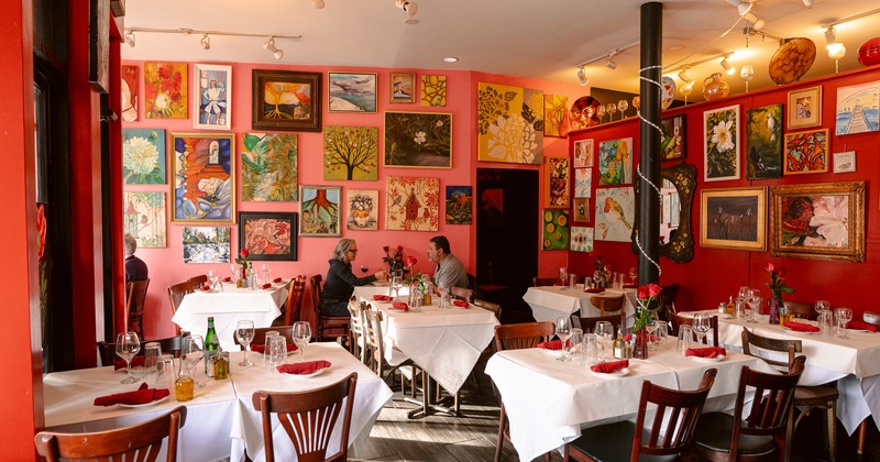 Interior of vivid and cozy dining area with dining tables set for guests