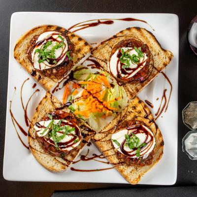 Bruschetta served with red wine, salt and pepper shaker.